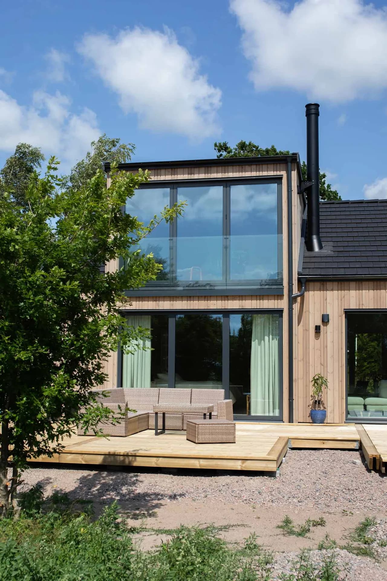 Unikt hus med stora fönster och stående träfasad