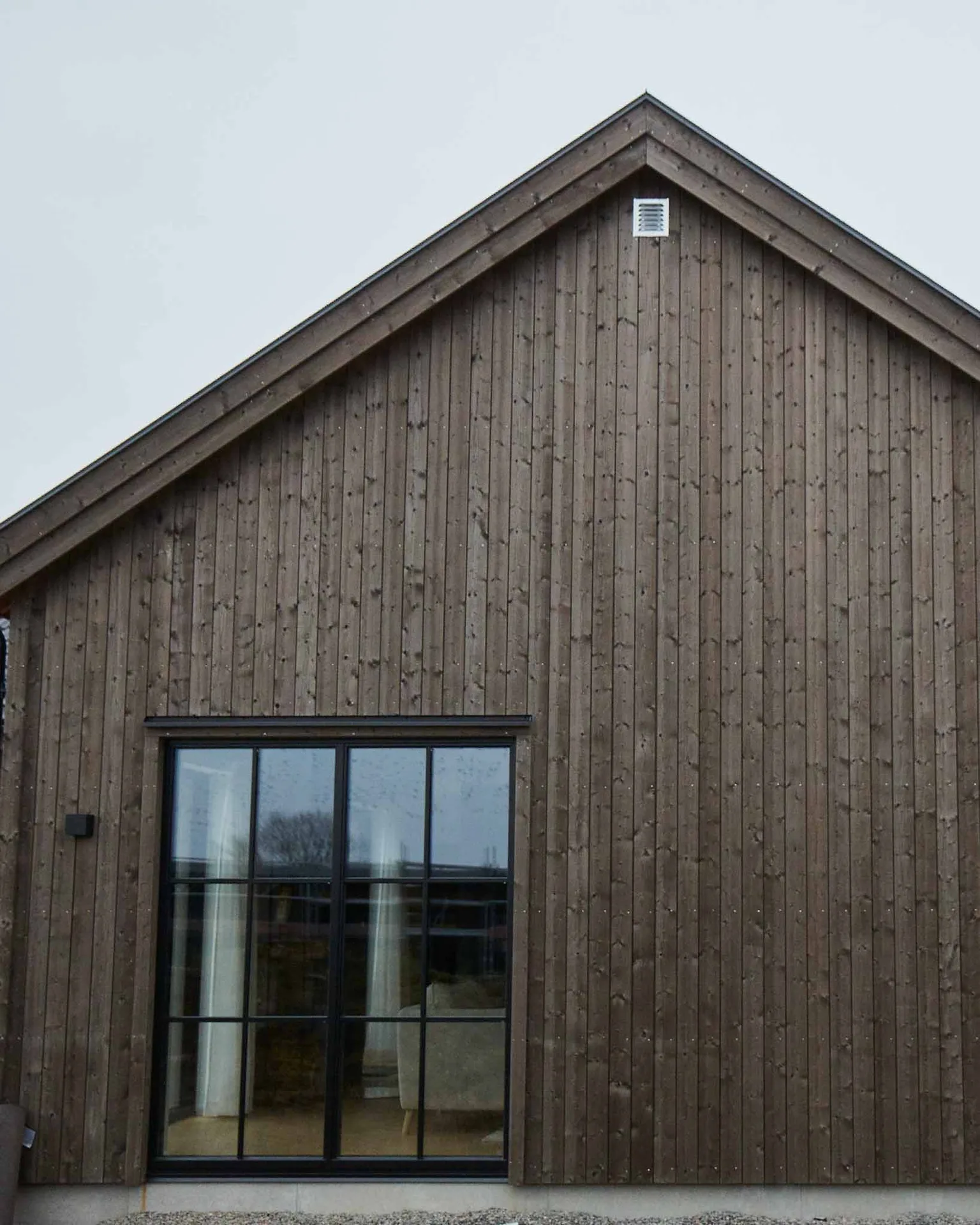 Arkitektritat enplanshus med stora fönster i industriell stil.